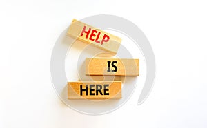 Help is here and support symbol. Concept words Help is here on wooden blocks on beautiful white table white background. Business,