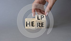 Help is here symbol. Businessman hand Turnes cube and changes word Here to Help. Beautiful grey background. Business and Help is