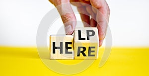 Help is here symbol. Businessman turns a cube and changes the word help to here. Beautiful white and yellow background, copy space