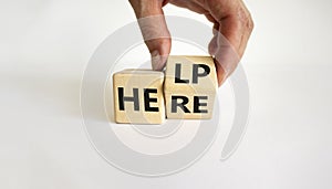 Help is here symbol. Businessman turns cubes and changes the word help to here. Beautiful white background, copy space. Business,