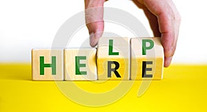 Help is here symbol. Businessman turns cubes and changes the word help to here. Beautiful white background, copy space. Business,