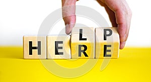 Help is here symbol. Businessman turns cubes and changes the word help to here. Beautiful white background, copy space. Business,