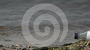 Help message in bottle on inhabitant island beach, person in wildlife conditions