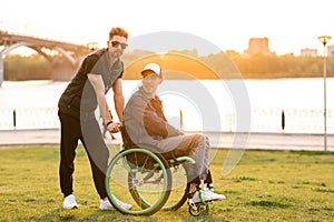 Help for people with physical disabilities. Man drive wheelchair and help his friend. Social services for population.