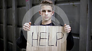 Help sign in homeless orphan hands, child begging help, needs social support
