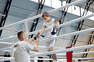 Help, support. Junior athlete, male boxer training with personal coach at sports gym, indoors. Concept of studying