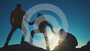 help team concept. team silhouette of climber stretching a helping hand to a friend. business teamwork success concept