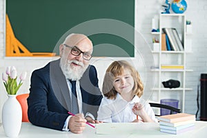 Help to learn. Pupil child lesson. School teacher. Education concept. Old teacher with schoolboy in classroom.