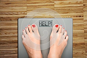 Help to lose kilograms with woman feet stepping on a weight scale