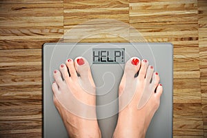 Help to lose kilograms with woman feet stepping on a weight scale