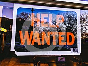 Help Wanted Sign Hanging On Business Window