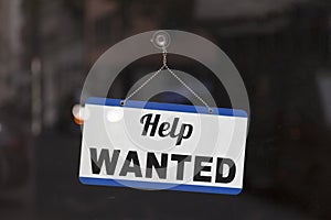 Help wanted sign in the window of a shop