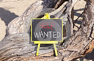 Help wanted and support symbol. Concept words Help wanted on beautiful black yellow blackboard. Beautiful tree background.
