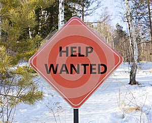 Help wanted and support symbol. Concept words Help wanted on beautiful red road sign. Beautiful forest snow blue sky background.