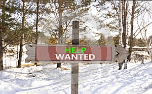 Help wanted and support symbol. Concept words Help wanted on beautiful wooden road sign. Beautiful forest snow blue sky background