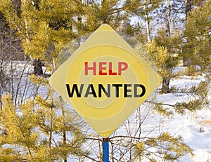 Help wanted and support symbol. Concept words Help wanted on beautiful yellow road sign. Beautiful forest snow blue sky background