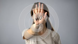 Help written on womans hand, human trafficking, cruel treatment, sexual assault