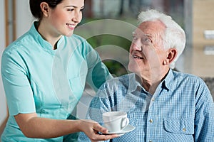 Helper giving cup of coffee photo