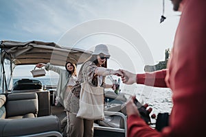 Boatman assisting young woman disembarking from a boat with care photo