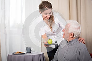 Helpful nurse and smiling pensioner