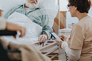 Helpful nurse switching on a professional bed