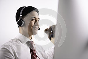 Helpful operator dispatcher wearing headset assisting customers in customer support service taking phone calls at office