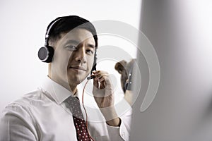 Helpful operator dispatcher wearing headset assisting customers in customer support service taking phone calls at office