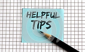 HELPFUL TIPS   the phrase is written on colored stickers  on a notepad background. Business concept