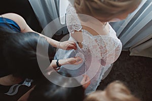 Helping the bride to put her wedding dress