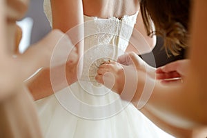 Helping the bride to put her wedding dress