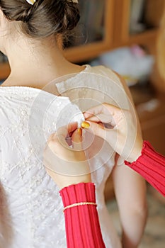 Helping the bride to put her wedding dress on