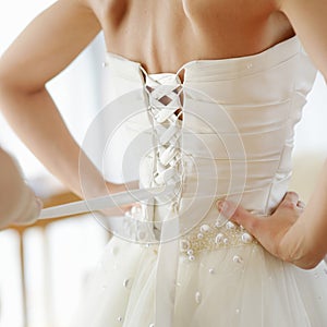 Helping the bride to put her wedding dress