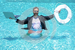 Helping business. Business man in suit hold laptop and help lifebuoy in swim pool. Rescue help swimming ring in water