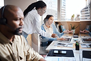 Helping future generations succeed. two businesswomen using a headset and computer while working in a modern office.