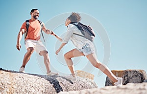 Helping hand, couple and rock climbing or hiking in nature on vacation, holiday or trip. Teamwork, support and traveling