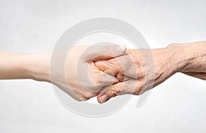 Helping hand for the elderly concept with young hand holding old hand