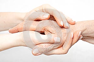 Helping hand for the elderly concept with young hands holding old hand