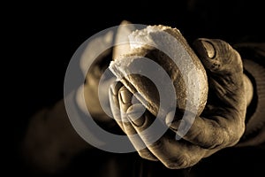 Helping hand giving a piece of bread. Poor Man sharing Bread, Helping Hand Concept. Amber close up