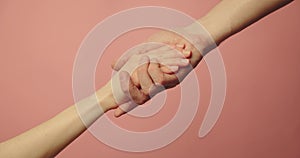 Helping hand - support, assistance and charity concept. hands reaching together on pink background