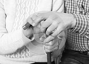 Helping hands, care for elderly concept. Close-up handshake. Black and white photo