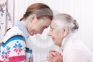 Helping hands, care for the elderly concept Senior and caregiver holding hands at home