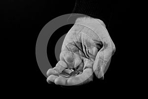 Helping hands concept, Rich giving the poor, Man`s hands palms up holding money coins, reaching out, black and white