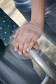 Helping hands on elderly woman's walker