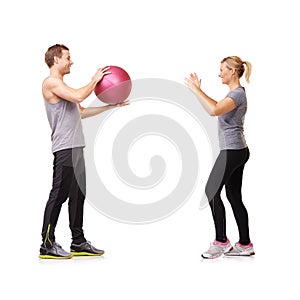 Helping her train. A man and woman exercising by throwing a medicine ball to each other.