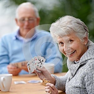 Helping the time pass with card games. Two seniors playing cards together.