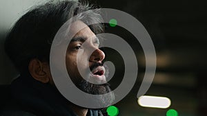 Helpless homeless Indian depressed stressed bearded man suffer at dark parking lot city night froze Arabian stressful