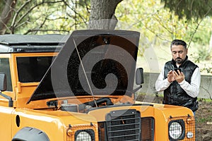 Helpless man beside his car