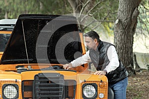 Helpless man beside his car