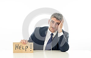 Helpless mature businessman holding a help sign in financial crisis unemployment stress and depression concept isolated in white