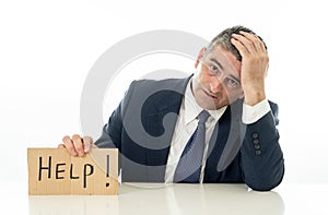 Helpless mature businessman holding a help sign in financial crisis unemployment stress and depression concept isolated in white